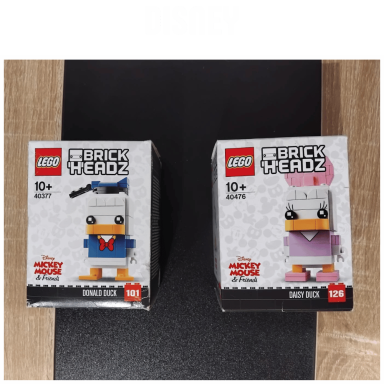 Due figure LEGO a forma di anatra con stili diversi, uno blu e uno rosa.